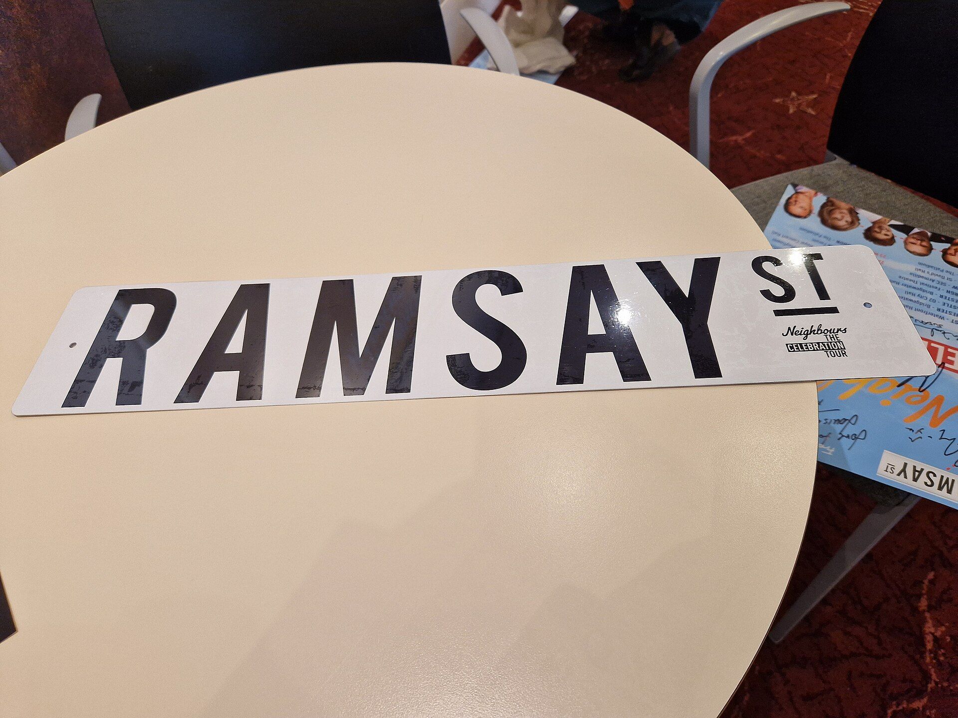 A Ramsay Street sign from the Neighbours celebration tour, lying on a table