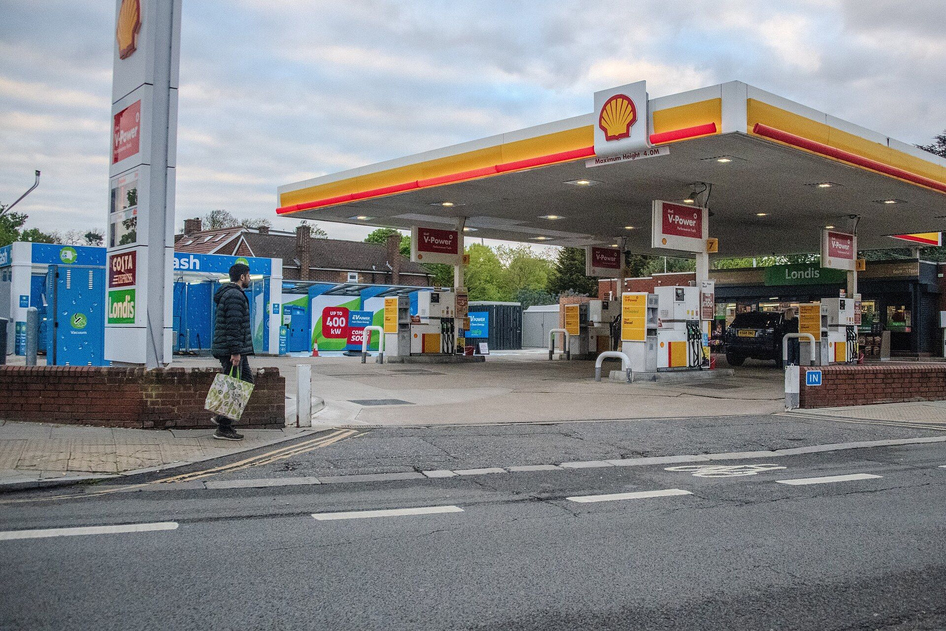 A Shell petrol station in Hounslow, London, with a man walking past carrying a shopping bag